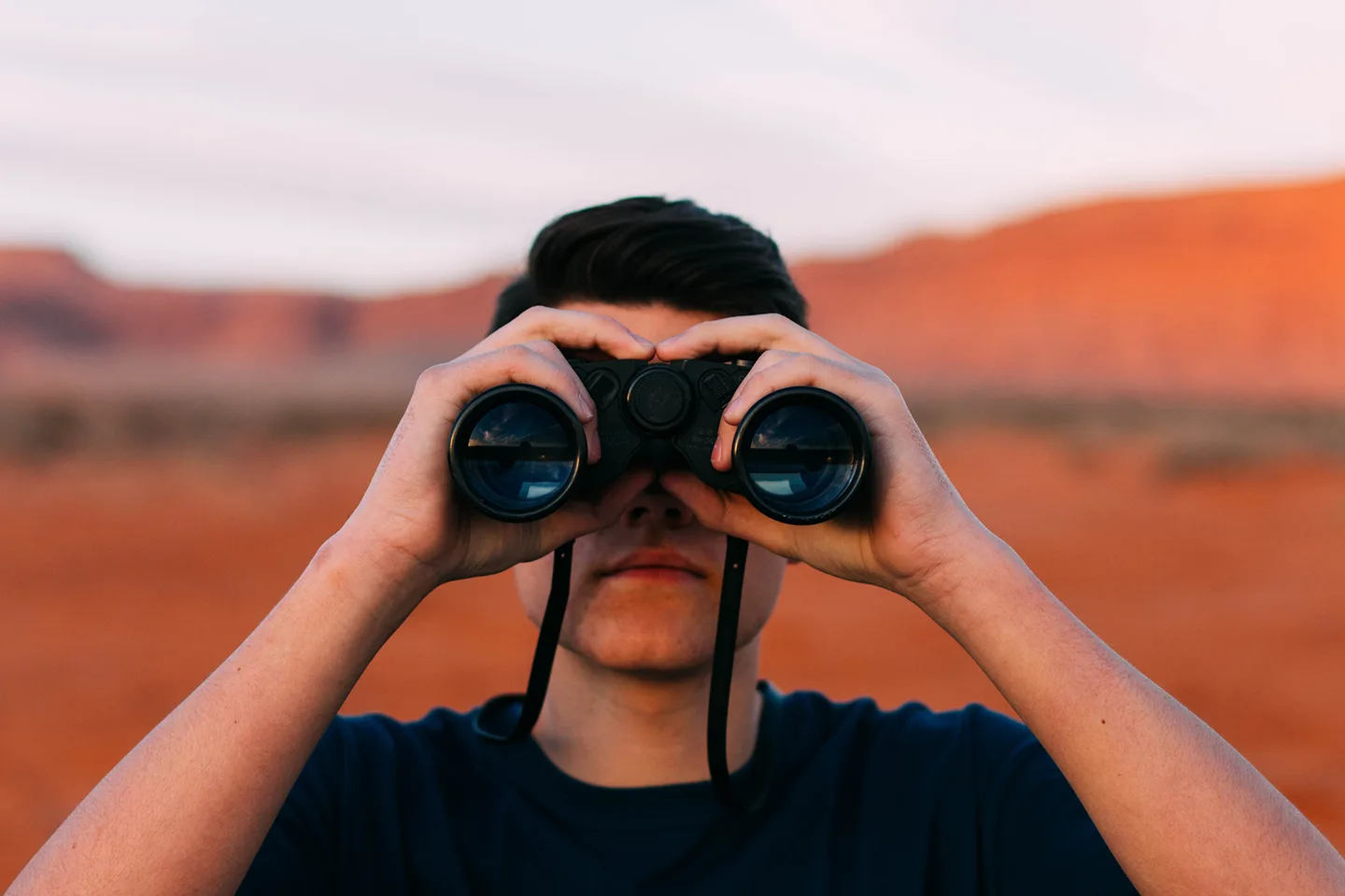 A person looking through binoculars, illustrating visibility.