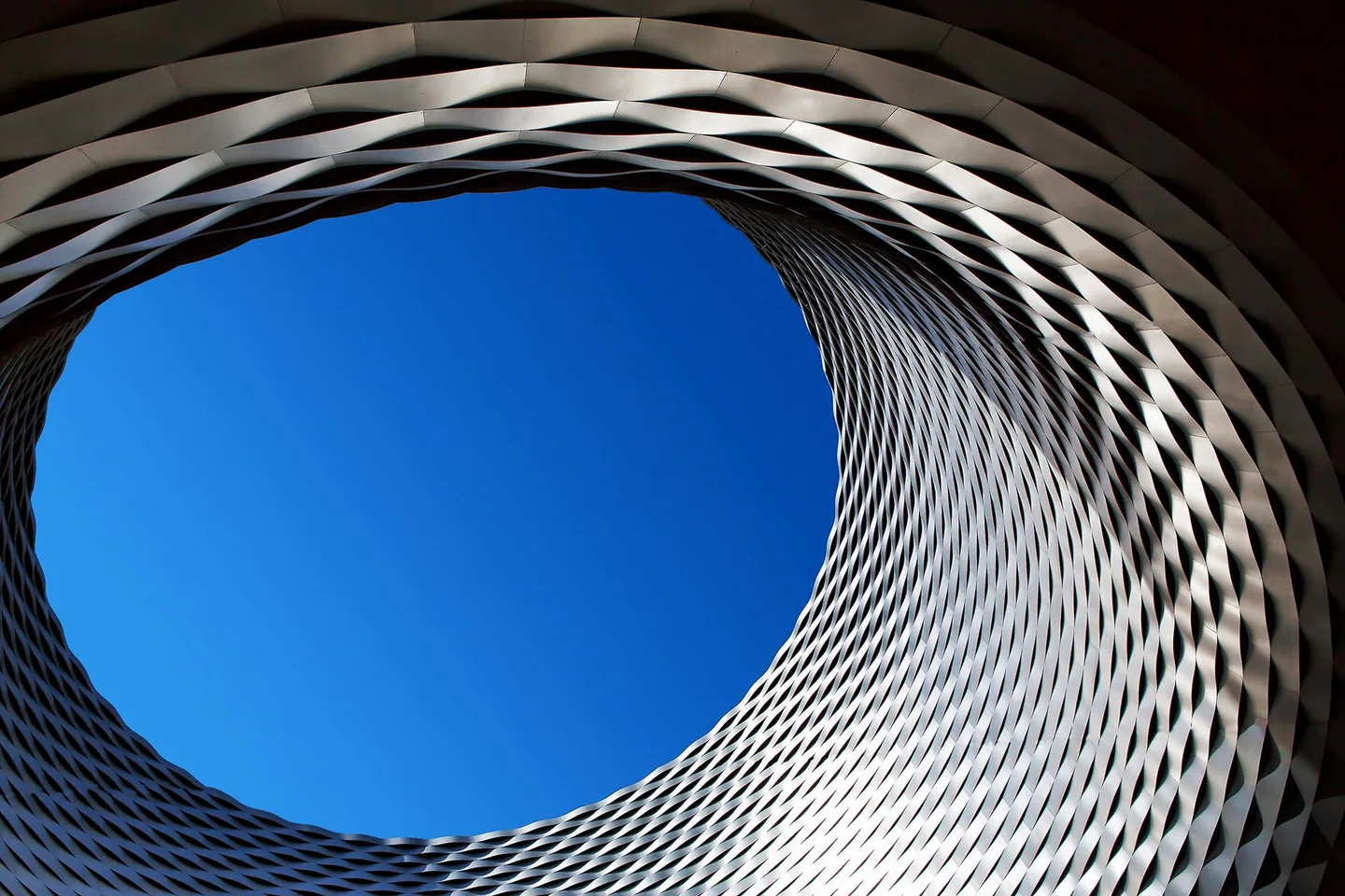 An architectural photograph looking upwards towards a blue sky.