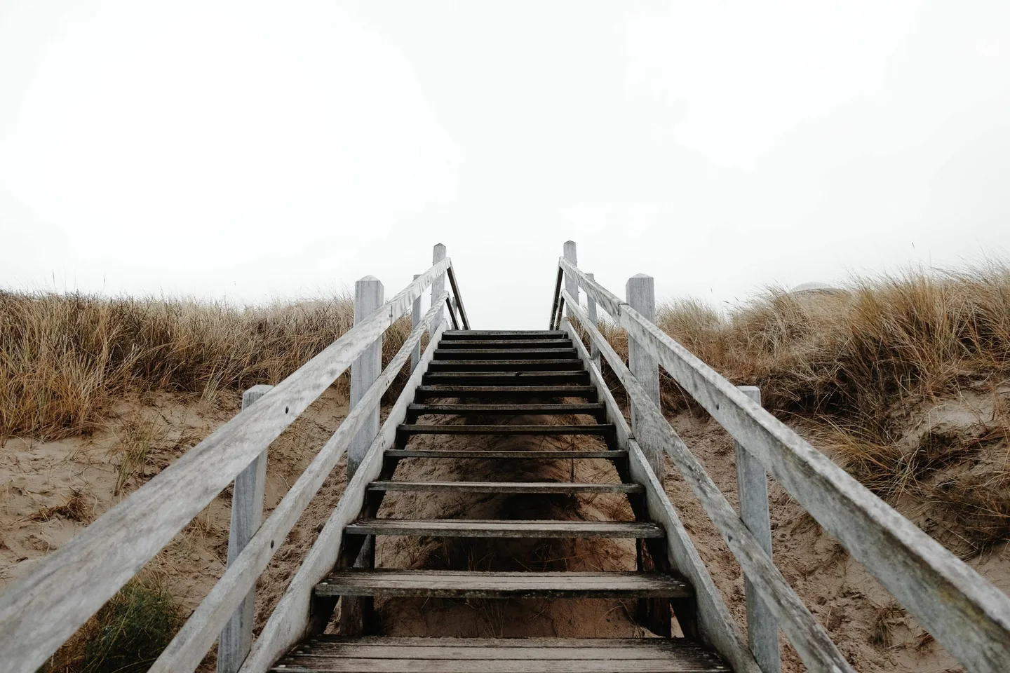 Steps through sand dunes, illustrating a gradual process.