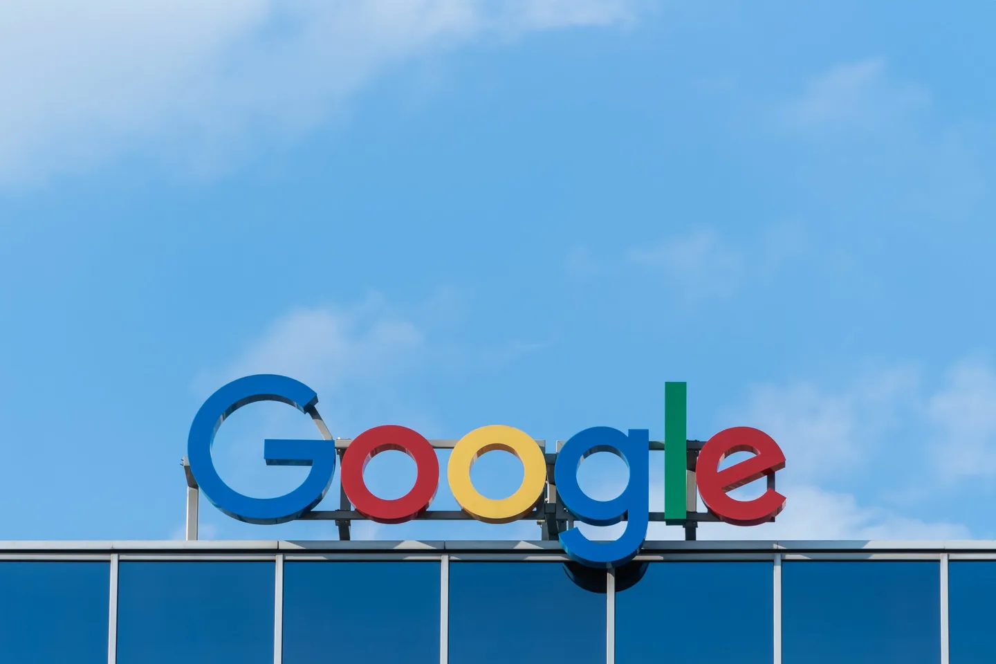 A Google sign on a building against a blue sky.