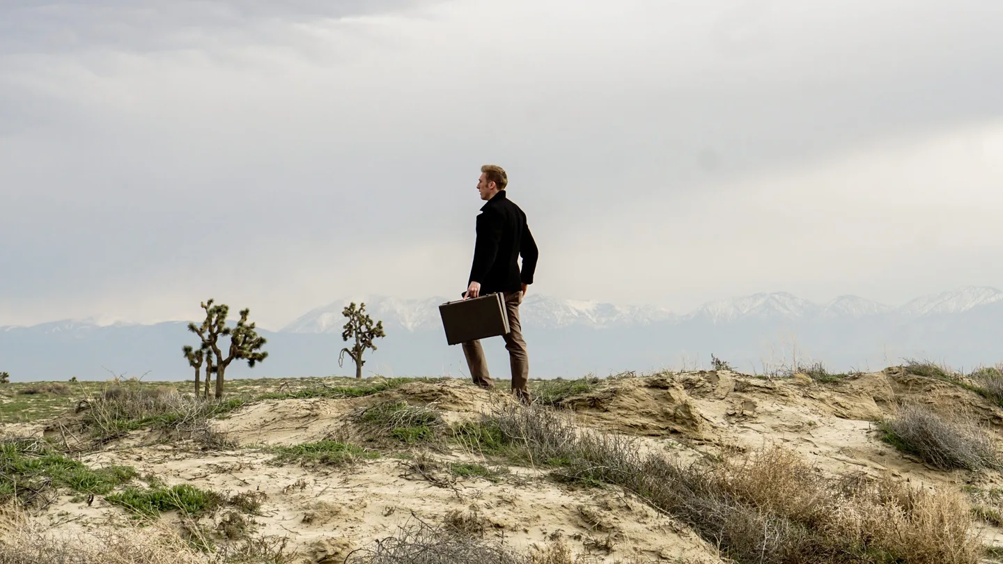 A person on a path through an open landscape.